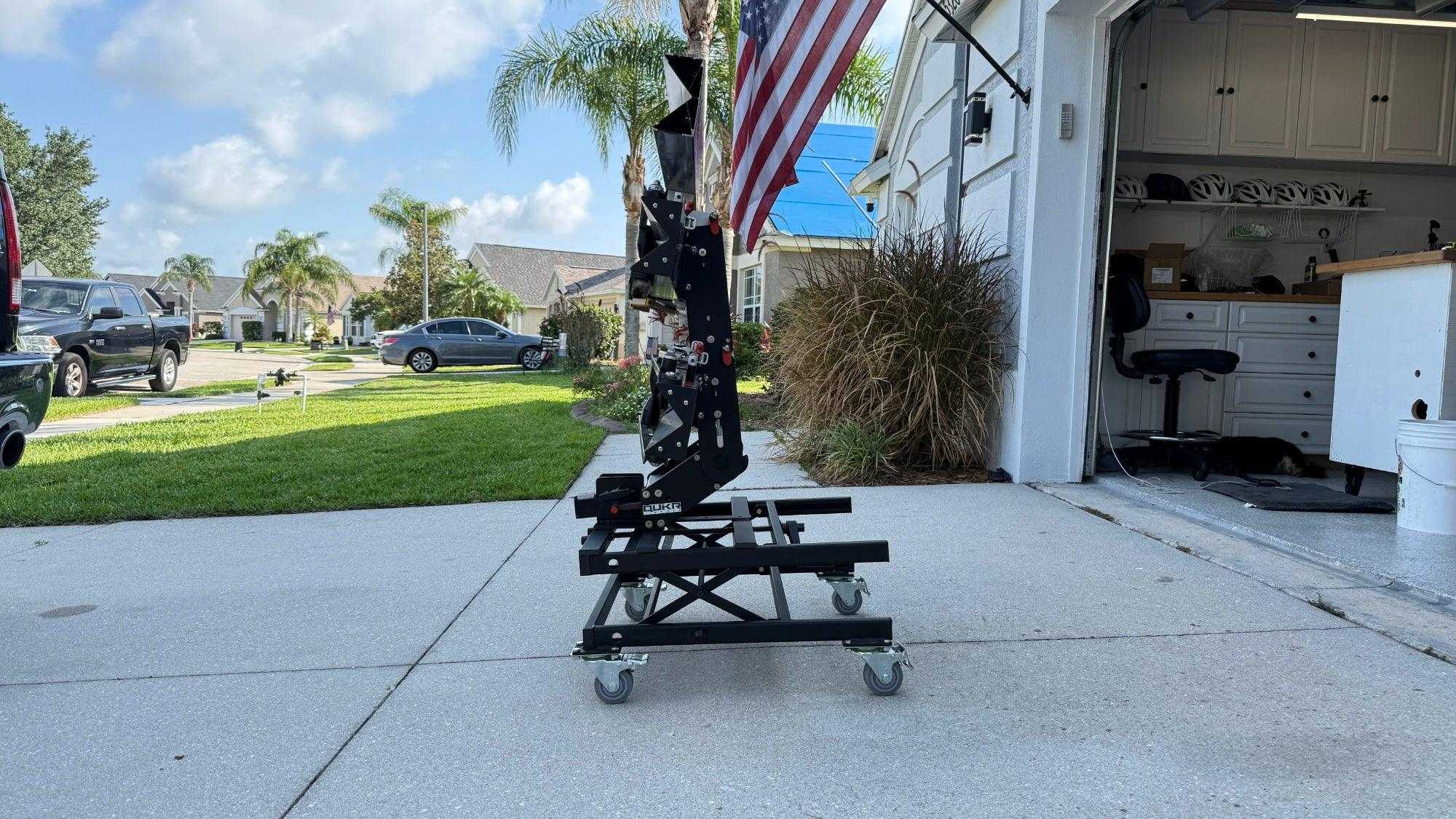 Portable black eBike rack lift with wheels for easy storage and hitch alignment.