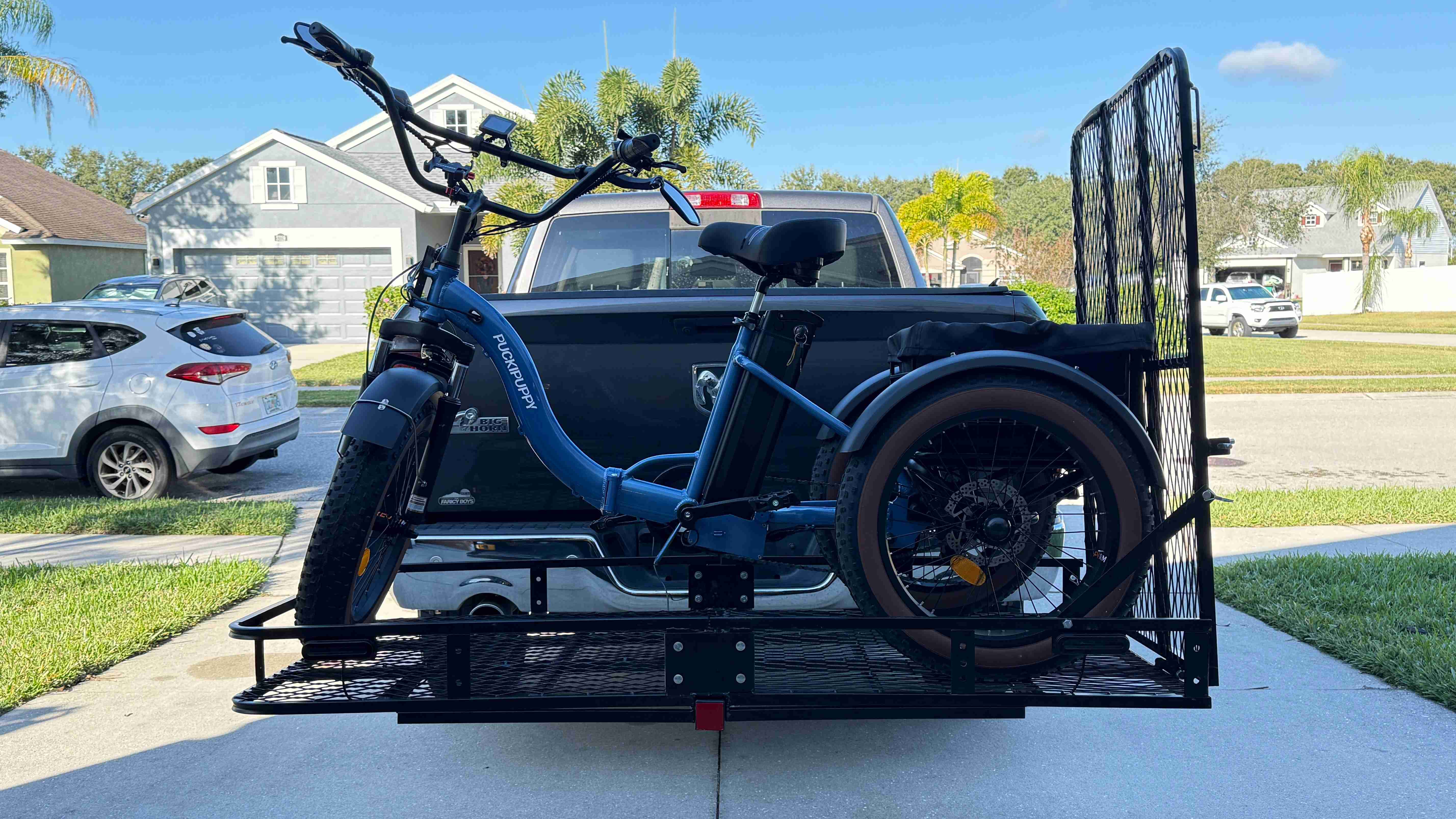 Blue eTrike secured on a hitch-mounted platform rack