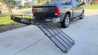 Hitch-mounted mesh cargo basket with a long folding loading ramp extended to the ground